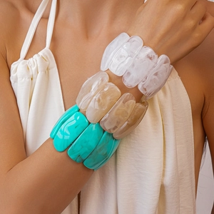 Close-up of wide acrylic stretch bracelets with marbled texture in white amber and green