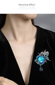 Detailed view of luxury butterfly brooch with blue heart crystal and teardrop tassel