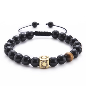 Detail of tiger eye stone and gold micro-pave zircon square bead on black stone bracelet