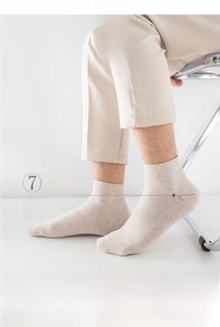 Detailansicht der 7-förmigen Fersennaht und des gerippten Bündchens an beigen Socken