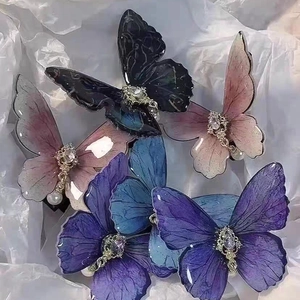 Set of 5 Chinese style butterfly hair clips with pearls and rhinestones on white paper