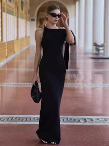 Elegant black one-shoulder slim-fit maxi dress for women in a classic hallway setting