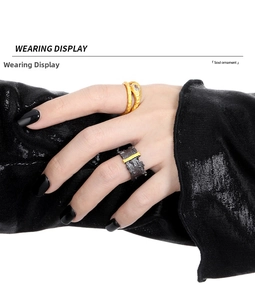 Wearing display of irregular texture black ring and gold rope ring with crystal detail