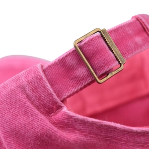 Detail of adjustable metal buckle on washed pink denim baseball cap with MAMA embroidery
