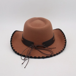 Detail of brown felt cowboy hat featuring black woven edges and decorative leather band