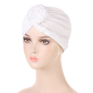 Dettaglio di un turbante bianco in maglia elastica con nodo circolare intrecciato a mano