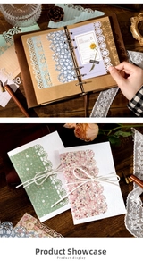 Detailed view of hollow lace scrapbooking paper with vintage floral patterns on dark wood