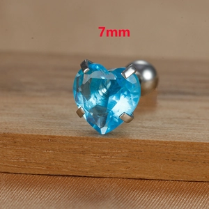 Macro shot of a 7mm heart-shaped blue zircon stud earring with silver titanium steel prongs
