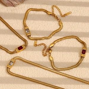 Detail of 18K gold plated snake chains featuring red and white zircon gemstones