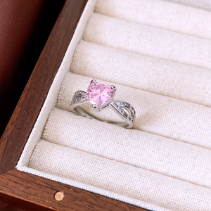 Detail of pink heart-shaped gemstone ring with silver crossover pavé band in a box