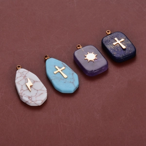Detailed view of stainless steel pendants with inlaid natural stones and sun cross motifs