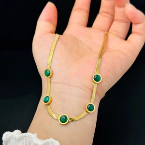 Flat snake chain necklace in gold finish with five round emerald green gemstones
