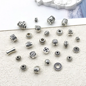 Macro detail of various Tibetan silver floral beads and charms for DIY jewelry making