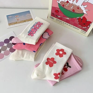 Vista dettagliata di calze di cotone rosa e bianche con motivi jacquard a cuore