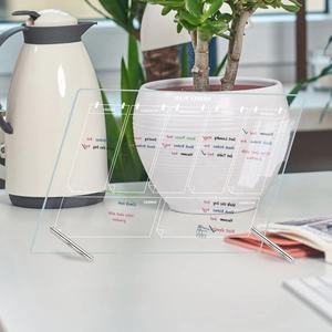 Macro view of clear acrylic weekly plan board with metal stand and seven day sections