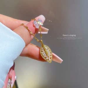 Elegant gold titanium leaf necklace featuring micro-set cubic zirconia on a model