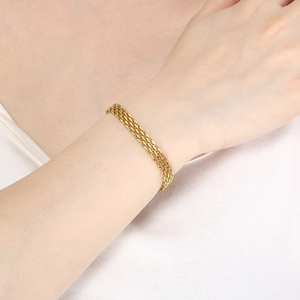 Minimalist multi-layer woven titanium steel bracelet in gold on a female wrist