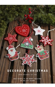 Flat lay of festive wooden Christmas ornaments with reindeer and stars on dark wood