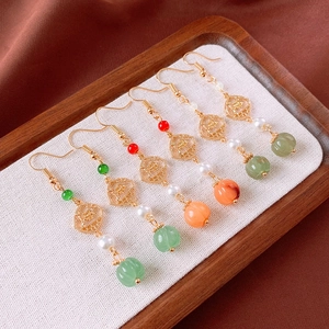 Detail of vintage flower earrings with pearls and pumpkin beads on a tray