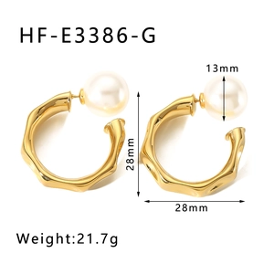 Detail shot of gold C-shaped earrings with 13mm white pearls and irregular metal texture