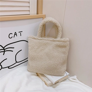 Borsa tote in lana di agnello bianco panna su libri in un ambiente accogliente