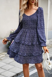 Detail of blue floral V-neck dress with elastic pleated chest and ruffled layered hemline