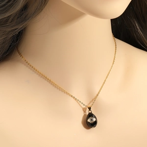 Detail of evil eye water drop pendant necklace with micro-pave zircons on gold chain