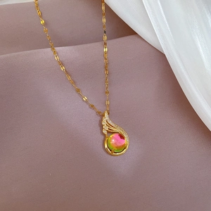 Close-up of gold titanium necklace with iridescent stone and micro-pave wing pendant