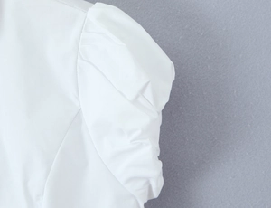 Detail of elegant white puff sleeves with delicate pleated fabric texture and stitching