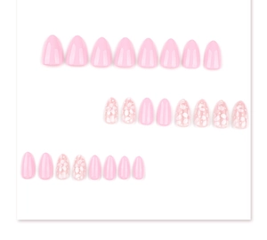 Vue à plat de faux ongles amande roses avec motifs floraux blancs sur fond blanc