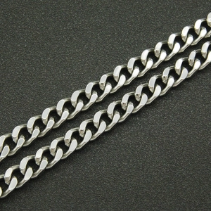 Macro shot of silver stainless steel Cuban link chain with polished metallic finish