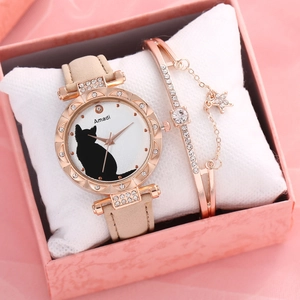 Close-up of cat motif watch and star bracelet set inside a pink marble gift box