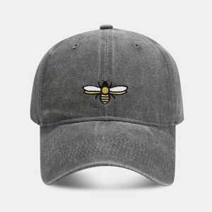 Close-up of a vintage washed cotton baseball cap with detailed yellow bee embroidery