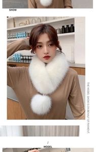 Close-up of a white faux fur scarf with soft pom-poms and cross-wear style detail