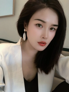 Detail of elegant white enamel teardrop earrings on model with gold-plated finish