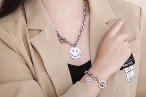 Detail of silver stainless steel chain set with smiley face pendant and T-bar toggle clasp