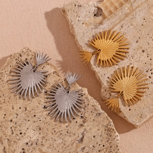Detailed texture of gold and silver sunburst earrings on natural stone surface