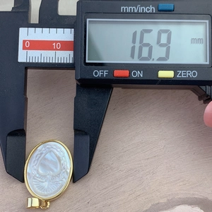 Oval white mother of pearl Sacred Heart pendant measured at 16.9mm with digital caliper