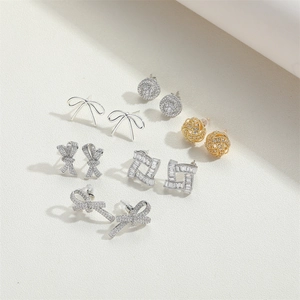 Macro shot of assorted gold and silver bow and geometric earrings with sparkling crystals
