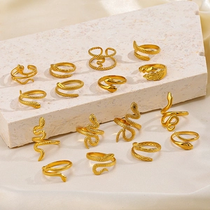 Collection of vintage 18K gold plated stainless steel snake rings on stone surface