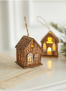 Dettaglio di una casetta di Natale in legno con LED posata su pagine di un libro vintage