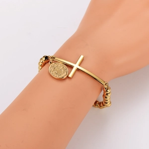 Bracelet à perles dorées avec croix et médaille de Saint-Benoît présenté sur un mannequin