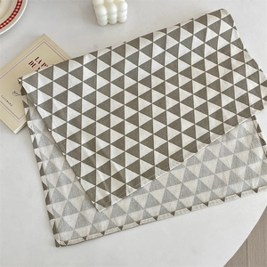 Détail du set de table géométrique gris et blanc avec motif triangle pour la salle à manger