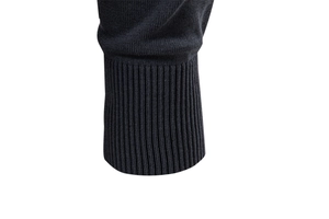 Close-up of ribbed cuffs on a black knit polo sweater showing detailed fabric texture