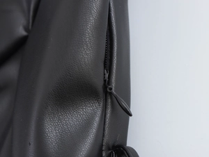 Gros plan détaillé du cuir PU noir et de la fermeture éclair invisible sur la robe