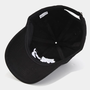 Detailansicht der schwarzen Baumwollkappe mit weißem Stickdetail und verstellbarem Riemen