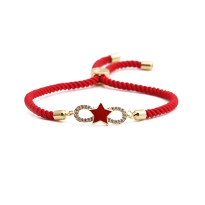 Red braided rope bracelet with golden infinity symbol and star detail on white background