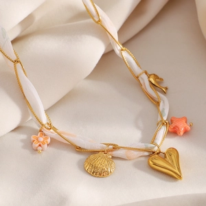 Detail van geweven 18K vergulde ketting met kleurrijke bedeltjes en stoffen details