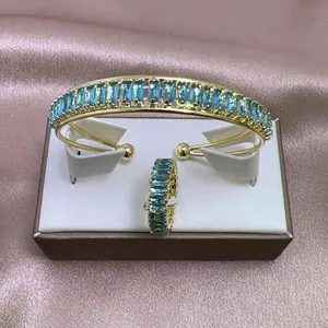 Detalle del conjunto de brazalete y anillo de oro con circonitas verde esmeralda en satén