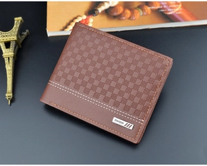 Detail shot of brown leather wallet with plaid pattern and Eiffel Tower decoration